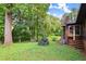 Landscaped backyard featuring a brick home exterior, multilevel wooden deck, mature trees, and flowering bushes at 2600 Sandpiper Dr, Tucker, GA 30084