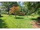 Expansive backyard featuring lush green grass, mature trees, and a charming elevated deck at 2600 Sandpiper Dr, Tucker, GA 30084