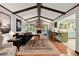Open-concept living room featuring wood floors, a beamed ceiling, and a brick fireplace at 2600 Sandpiper Dr, Tucker, GA 30084