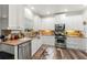 Well-lit kitchen featuring ample white cabinets, stainless steel appliances, and hardwood floors at 58 Lilyfield Ln, Acworth, GA 30101