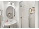 Stylish powder room with a sleek pedestal sink, oval mirror, and modern fixtures at 58 Lilyfield Ln, Acworth, GA 30101