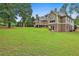 Beautiful backyard featuring a spacious lawn, trees, and back view of home with a deck at 245 Maple Shade Dr, Tyrone, GA 30290