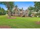 Charming backyard view featuring a home with deck, lush lawn, and mature trees at 245 Maple Shade Dr, Tyrone, GA 30290