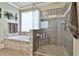 Bathroom with a tiled shower featuring a glass door and built-in shelves next to a soaking tub at 245 Maple Shade Dr, Tyrone, GA 30290