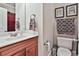 Well-lit bathroom with a wood vanity, framed artwork and a large mirror at 245 Maple Shade Dr, Tyrone, GA 30290