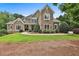 Beautiful two-story home featuring stone and siding, enhanced by lush landscaping at 245 Maple Shade Dr, Tyrone, GA 30290