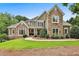 Stunning two-story home with stone and siding exterior, complemented by a lush, manicured lawn at 245 Maple Shade Dr, Tyrone, GA 30290