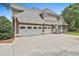 Three-car garage showcasing carriage doors and plenty of parking space on the driveway at 245 Maple Shade Dr, Tyrone, GA 30290
