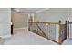 Open hallway area with carpeted floor and decorative wood and iron banister at 245 Maple Shade Dr, Tyrone, GA 30290