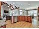 Open kitchen and living area with wooden floors, exposed beams and stainless steel appliances at 245 Maple Shade Dr, Tyrone, GA 30290
