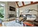Bright living room with a stone fireplace, beamed ceilings, and natural light at 245 Maple Shade Dr, Tyrone, GA 30290