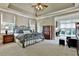 Tranquil bedroom with a decorative iron bed frame, tray ceilings and sitting area at 245 Maple Shade Dr, Tyrone, GA 30290