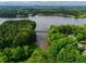 An aerial view showcases a lake and forested area with a bridge and houses nestled among the trees at 4520 Dallas St, Acworth, GA 30101