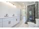 Bathroom with double sinks, modern vanity, tiled floors and a glass-enclosed shower at 0 Thompson Mill Rd, Buford, GA 30519