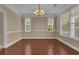 Formal dining room featuring hardwood floors, elegant chandelier, and bright windows at 102 Plantation Dr, Lagrange, GA 30277