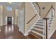 Bright foyer with dark hardwood floors, a staircase with wood and white railings, and a view of the front door at 102 Plantation Dr, Lagrange, GA 30277