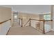 Upstairs hallway with carpet, white railings, and views to the outside through the windows provides natural light at 102 Plantation Dr, Lagrange, GA 30277