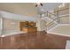 Open-concept living room with hardwood floors connecting to the kitchen and staircase at 102 Plantation Dr, Lagrange, GA 30277