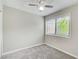 Bright bedroom featuring gray carpet, a window, and a ceiling fan with a light at 1301 Parkaire Xing, Marietta, GA 30068