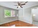 A cozy bedroom featuring hardwood floors, a ceiling fan, and a bright window at 1301 Parkaire Xing, Marietta, GA 30068