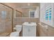 Well-lit bathroom featuring shower with glass doors and marble tile throughout at 1618 Mason Mill Ne Rd, Atlanta, GA 30329