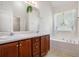 Bathroom featuring a double vanity, soaking tub, and large window at 40 Browning Dr, Covington, GA 30016
