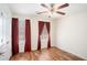 A bright bedroom featuring hardwood floors, a ceiling fan, and stylish curtains at 40 Browning Dr, Covington, GA 30016