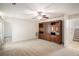 Spacious living room with tan carpet, a ceiling fan, and a built-in wooden cabinet at 40 Browning Dr, Covington, GA 30016