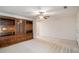 Spacious living room with tan carpet, a ceiling fan, and a built-in wooden cabinet at 40 Browning Dr, Covington, GA 30016