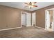 Spacious bedroom with neutral walls and carpet, ceiling fan, and two closets at 406 Heritage Park Nw Trce # 22, Kennesaw, GA 30144