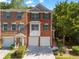 Townhouse complex featuring brick exterior, attached garages, and manicured landscaping at 406 Heritage Park Nw Trce # 22, Kennesaw, GA 30144