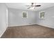 Spacious bedroom with plush carpet, two windows with blinds, and a ceiling fan at 1724 Rhonda Ln, Stone Mountain, GA 30087