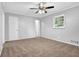 Neutral bedroom with ceiling fan, window letting in natural light and plush carpet flooring at 1724 Rhonda Ln, Stone Mountain, GA 30087