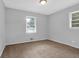 Neutral bedroom with two windows letting in natural light and plush carpet flooring at 1724 Rhonda Ln, Stone Mountain, GA 30087