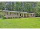 Charming brick home with a covered front porch, well-manicured lawn, and lush, mature landscaping at 1724 Rhonda Ln, Stone Mountain, GA 30087