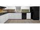 Bright kitchen featuring white cabinets and black appliances at 1724 Rhonda Ln, Stone Mountain, GA 30087