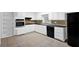 Clean kitchen with white cabinets, tile backsplash, and black appliances at 1724 Rhonda Ln, Stone Mountain, GA 30087