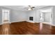 Bright living room featuring hardwood floors, white brick fireplace, and an open doorway to other rooms at 1724 Rhonda Ln, Stone Mountain, GA 30087