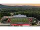 Aerial view of a football field with track, bleachers, and surrounding trees and mountains at 513 Godfrey Dr, Cumming, GA 30040