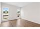 Bright bedroom with wood floors, two windows, and neutral walls offers a peaceful retreat at 513 Godfrey Dr, Cumming, GA 30040