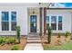 Inviting front entrance with a glass door, wooden pillars and brick-lined steps at 513 Godfrey Dr, Cumming, GA 30040