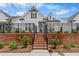 Charming home with a brick retaining wall, a black fence, and inviting steps leading to the entrance at 513 Godfrey Dr, Cumming, GA 30040