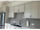 Well-lit kitchen with white cabinetry, stainless steel appliances, and stylish tile backsplash at 513 Godfrey Dr, Cumming, GA 30040