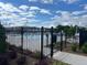 Community pool area featuring a black iron fence, lounge chairs, and a picturesque skyline with beautiful blue skies at 513 Godfrey Dr, Cumming, GA 30040