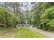 Landscaped front yard leading to a cozy home surrounded by mature trees at 2806 Hedgewood Nw Dr, Atlanta, GA 30311