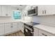 Kitchen with white cabinets and quartz countertops, stainless steel appliances, and a window over the sink at 2806 Hedgewood Nw Dr, Atlanta, GA 30311
