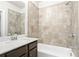 Bathroom featuring tub with tiled walls, dark vanity, mirror and a brushed nickel faucet at 3657 Atherton Park Ct, Suwanee, GA 30024