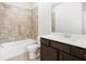Bathroom with tiled shower over tub, wood-look floors, and vanity with stone counters at 3657 Atherton Park Ct, Suwanee, GA 30024
