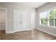 Bedroom with wood-look floors, neutral walls, large window, and white trim at 3657 Atherton Park Ct, Suwanee, GA 30024