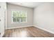 Bedroom with wood-look floors, neutral walls, large window, and white trim at 3657 Atherton Park Ct, Suwanee, GA 30024